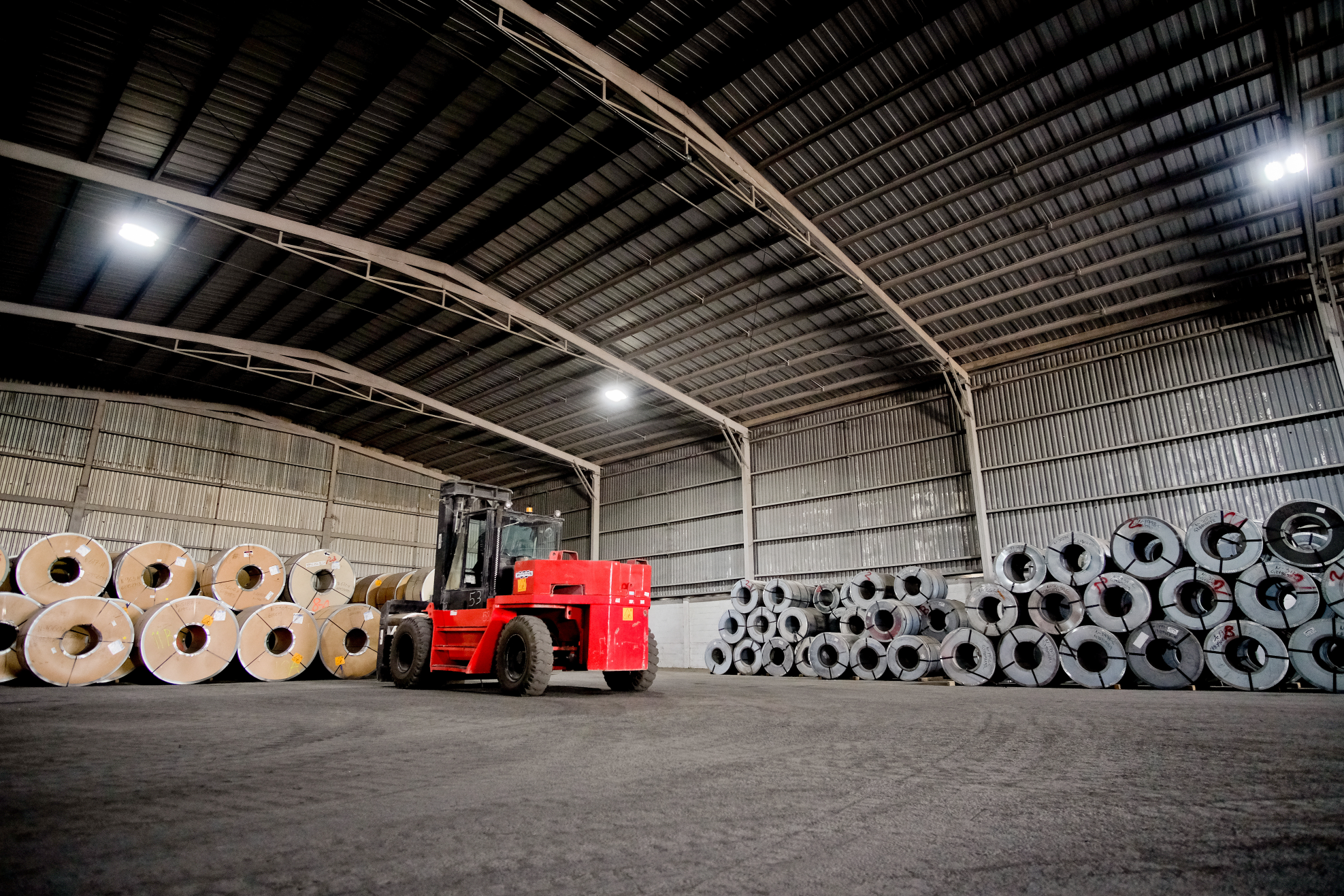 Áreas de trabajo en donde se almacéna, carga y descarga producto. Maquinaria especializada para mover material pesado.